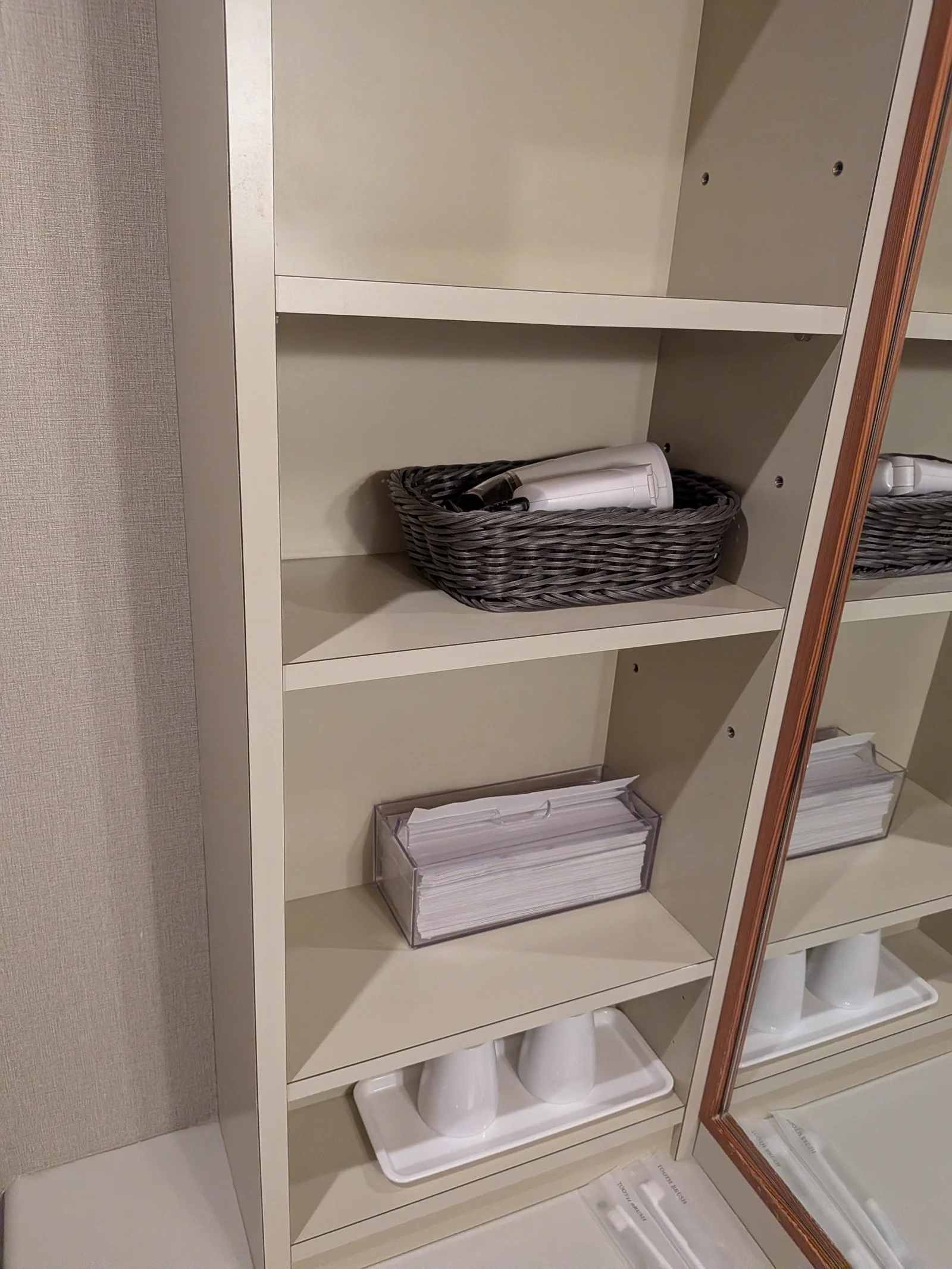 バスルームの棚にあるドライヤーとアメニティ